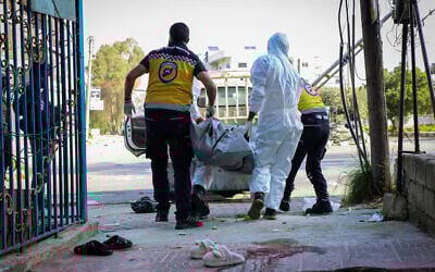 In this photo provided by the Syrian Civil Defense White Helmets, members of the Syrian White Helmets collect the bodies of people found dead following a recent wave of violence between Syrian security forces and gunmen loyal to former president Bashar al-Assad, as well as subsequent sectarian attacks, in the coastal city of Baniyas, Syria, March 9, 2025. (Syrian Civil Defense White Helmets via AP)