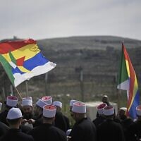 Druze clerics stand near the border, as they wait for buses carrying members of the Syrian Druze community to cross from Syria in the village of Majdal Shams, in the Golan Heights in northern Israel, March 14, 2025. (AP Photo/Leo Correa)