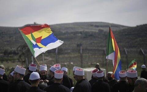 Druze clerics stand near the border, as they wait for buses carrying members of the Syrian Druze community to cross from Syria in the village of Majdal Shams, in the Golan Heights in northern Israel, March 14, 2025. (AP Photo/Leo Correa)