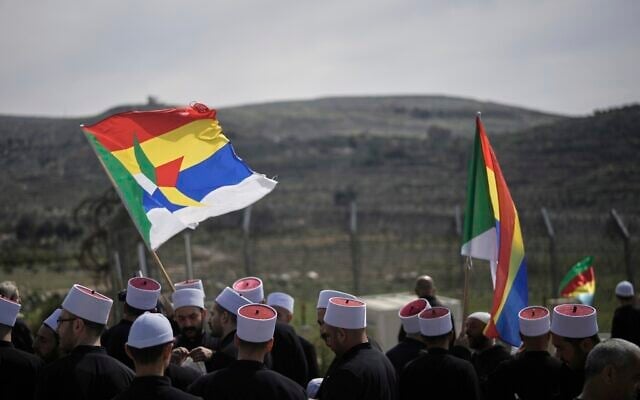 Druze clerics stand near the border, as they wait for buses carrying members of the Syrian Druze community to cross from Syria in the village of Majdal Shams, in the Golan Heights in northern Israel, March 14, 2025. (AP Photo/Leo Correa)