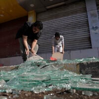 Yemenis clean debris in front of their shops after a US airstrikes in Sanaa, Yemen, Sunday, March 16, 2025. (AP Photo/Osamah Abdulrahman)