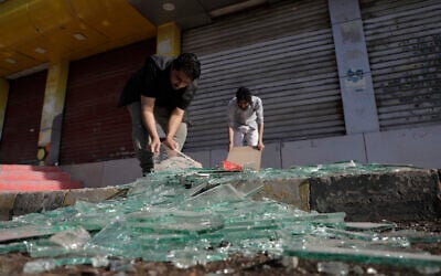Yemenis clean debris in front of their shops after a US airstrikes in Sanaa, Yemen, March 16, 2025. (AP/Osamah Abdulrahman)
