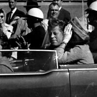 US President John F. Kennedy waves from his car in a motorcade approximately one minute before he was shot, in Dallas, November 22, 1963. Riding with President Kennedy are first lady Jacqueline Kennedy, right, Nellie Connally, second from left, and her husband, Texas Gov. John Connally, far left. (Jim Altgens/AP)
