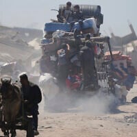 Palestinians carry their belongings while traveling from Beit Hanoun to Jabaliya, a day after Israel's renewed offensive in the Gaza Strip, March 19, 2025. (AP Photo/Jehad Alshrafi)