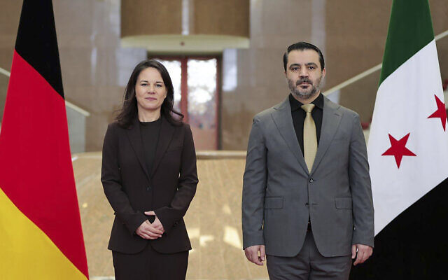 This photo released by the official Syrian news agency SANA, shows Germany's Foreign Minister Annalena Baerbock, left, and Syrian Foreign Minister Asaad Hassan al-Shibani, pose for a photograph in Damascus, Syria, Thursday, March 20, 2025. (SANA via AP)