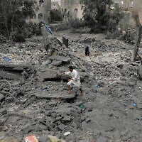 A Yemeni walks over the debris of a destroyed building following US airstrikes in Sanaa, Yemen, March 24, 2025. (AP)