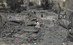 A Yemeni walks over the debris of a destroyed building following US airstrikes in Sanaa, Yemen, March 24, 2025. (AP)