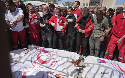 Mourners gather around the bodies of 8 Red Crescent emergency responders, recovered in Rafah in the Gaza Strip, on March 31, 2025. (AP/ Abdel Kareem Hana)