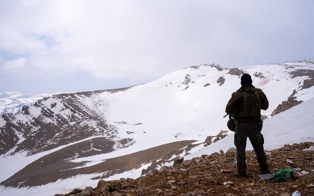 An IDF soldier stands next to an Israeli army post in the Mount Hermon area in southern Syria, March 11, 2025. (Emanuel Fabian/Times of Israel)