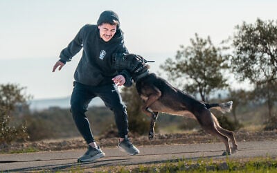 A trainer from Israel Protection K9 with one of the company's dogs. (Courtesy)