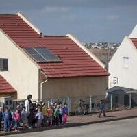 Young children cross the road in the West Bank outpost of Shvut Rachel, November 17, 2016 (Miriam Alster/ Flash90/ File)