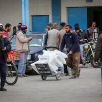 Palestinians receive food aid at a United Nations distribution center (UNRWA) in the southern Gaza Strip town of Rafah, on January 13, 2020. (Abed Rahim Khatib/ Flash90/ File)