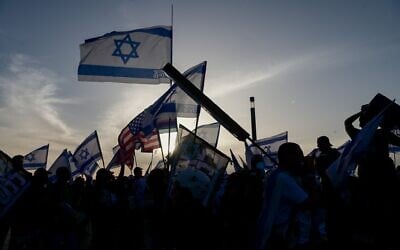 Anti-government protesters wave Israeli and American flags outside a Tel Aviv hotel hosting members of the 38th Zionist Congress, April 22, 2023. (Avshalom Sassoni/Flash90)