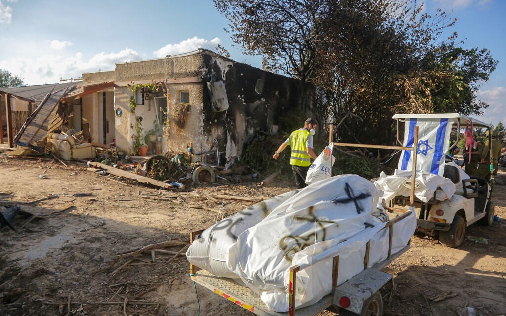 Members of Zaka walk through the destruction caused by Hamas terrorists in Kibbutz Kfar Aza, as they collect the dead bodies, near the Israeli-Gaza border, in southern Israel, October 15, 2023. (Edi Israel/ Flash90) Members of Zaka walk through the destruction caused by Hamas terrorists in Kibbutz Kfar Aza, as they collect the dead bodies, near the Israeli-Gaza border, in southern Israel, October 15, 2023. (Edi Israel/ Flash90)