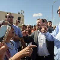 Heritage Minister Amichai Eliyahu (center) and MK Nissim Vaturi (right) attend a protest against the detention of Israeli reserve soldiers suspected of assaulting a Hamas terrorist, at the Sde Teiman military base near Beersheba, July 29, 2024. (Dudu Greenspan/Flash90)