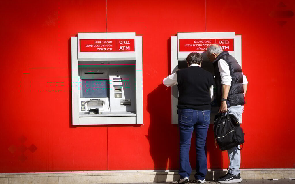 People withdraw money from a Bank Hapoalim ATM machine in Tel Aviv on December 9, 2024 (Miriam Alster/FLASH90) People withdraw money from a Bank Hapoalim ATM machine in Tel Aviv on December 9, 2024 (Miriam Alster/FLASH90)