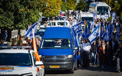 Israelis stand on the side of a road for the funeral convoy for the slain hostage Shlomo Mantzur in Rishon Lezion on March 2, 2025 (Yonatan Sindel/Flash90)