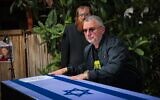 Dani Elgarat standing next to the coffin of his brother, Itzik Elgarat, during a funeral service outside the slain captive's home in Kibbutz Nir Oz, March 3, 2025 (Yossi Aloni/Flash90)