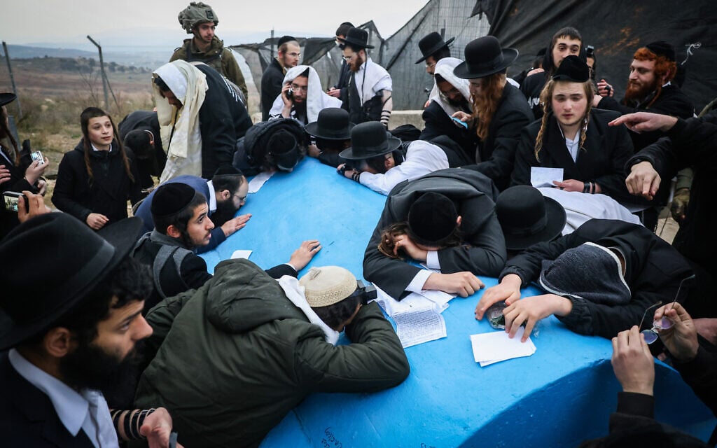 Ultra-Orthodox men pray at the tomb of the 4th century scholar Rav Ashi, which is located on the Israeli border with Lebanon, March 7, 2025. (David Cohen/Flash90)