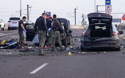 Police at the scene where a car exploded as a result of a suspected bombing, on the Ayalon Highway in Tel Aviv, March 9, 2025. (Avshalom Sassoni/Flash90)