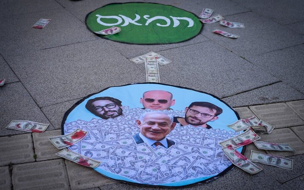 Protesters outside the Tel Aviv District Court, where Prime Minister Benjamin Netanyahu is attending a hearing in his corruption trial, draw attention to allegations of ties between the premier's senior aides and Qatar, and in turn, Hamas, March 10, 2025 (Avshalom Sassoni/Flash90)
