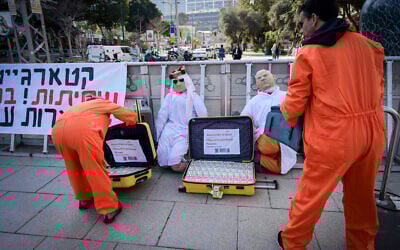 Israelis protest against Prime Minister Benjamin Netanyahu outside the district court in Tel Aviv, where he is testifying in his corruption trial, March 10, 2025. The display includes a 'suitcase of cash' representing Qatari payments to Gaza, and a banner about so-called 'Qatargate.' (Avshalom Sassoni/Flash90)