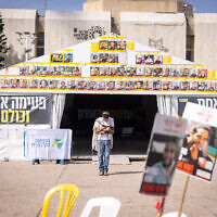 A man prays in front of posters of the Gaza hostages, in Tel Aviv's Hostages Square, March 17, 2025. (Miriam Alster/Flash90)