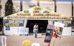 A man prays in front of posters of the Gaza hostages, in Tel Aviv's Hostages Square, March 17, 2025. (Miriam Alster/Flash90)