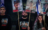 Former hostage Yarden Bibas, center, holds posters calling for the release of David and Ariel Cunio, at Hostage Square in Tel Aviv, March 18, 2025. (Avshalom Sassoni/Flash90)