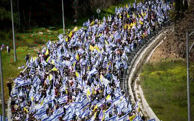 Protesters march against the decision of Prime Minister Benjamin Netanyahu to fire head of Shin Bet Ronen Bar, on Route 1 near Jerusalem, March 18, 2025. (Yonatan Sindel/Flash90)