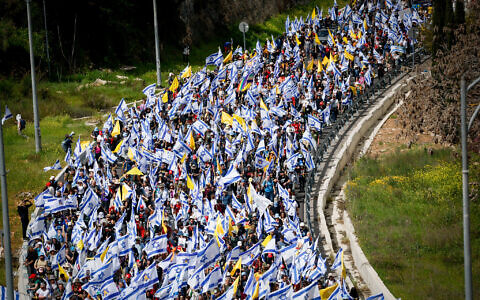 Protesters march against the decision of Prime Minister Benjamin Netanyahu to fire head of Shin Bet Ronen Bar, on Route 1 near Jerusalem, March 18, 2025. (Yonatan Sindel/Flash90)