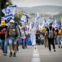 Protesters march for the release of hostages from Gaza and against efforts by Prime Minister Benjamin Netanyahu to fire Shin Bet head Ronen Bar, on Route 1 outside Jerusalem, March 18, 2025. (Photo by Yonatan Sindel/Flash90)