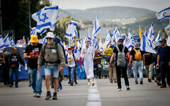 Protesters march for the release of hostages from Gaza and against efforts by Prime Minister Benjamin Netanyahu to fire Shin Bet head Ronen Bar, on Route 1 outside Jerusalem, March 18, 2025. (Photo by Yonatan Sindel/Flash90)