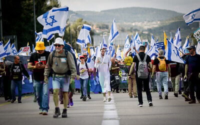 Protesters march for the release of hostages from Gaza and against efforts by Prime Minister Benjamin Netanyahu to fire Shin Bet head Ronen Bar, on Route 1 outside Jerusalem, March 18, 2025. (Photo by Yonatan Sindel/Flash90)