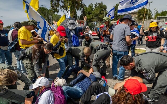 An anti-government protester presses up against a policewoman during a demonstration in Jerusalem, March 25, 2025. (Chaim Goldberg/Flash90) An anti-government protester presses up against a policewoman during a demonstration in Jerusalem, March 25, 2025. (Chaim Goldberg/Flash90)