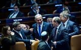 Prime Minister Benjamin Netanyahu speaks with fellow MKs in the Knesset plenum as the 2025 state budget is approved, March 25, 2025. (Yonatan Sindel/Flash90)