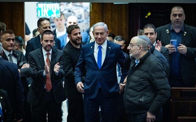 Prime Minister Benjamin Netanyahu (center) with coalition lawmakers as the 2025 state budget law is passed by the Knesset, March 25, 2025. (Yonatan Sindel/Flash90) Prime Minister Benjamin Netanyahu (center) with coalition lawmakers as the 2025 state budget law is passed by the Knesset, March 25, 2025. (Yonatan Sindel/Flash90)
