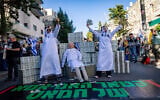 Demonstrators mock Prime Minister Benjamin Netanyahu, who was questioned that day in the investigation into his aides' ties to Qatar, and allude to  his years-long policy of facilitating Qatari payments to Hamas-run Gaza; Jerusalem, March 31, 2025. (Yonatan Sindel/Flash90)