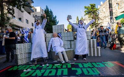 Demonstrators mock Prime Minister Benjamin Netanyahu, who was questioned that day in the investigation into his aides' ties to Qatar, and allude to  his years-long policy of facilitating Qatari payments to Hamas-run Gaza; Jerusalem, March 31, 2025. (Yonatan Sindel/Flash90)