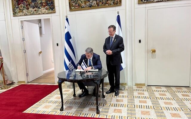 Greek Prime Minister Kyriakos Mitsotakis signs President Isaac Herzog’s guestbook ahead of a meeting at the President’s Residence in Jerusalem, March 30, 2025. (Nava Freiberg/Times of Israel) Greek Prime Minister Kyriakos Mitsotakis signs President Isaac Herzog’s guestbook ahead of a meeting at the President’s Residence in Jerusalem, March 30, 2025. (Nava Freiberg/Times of Israel)
