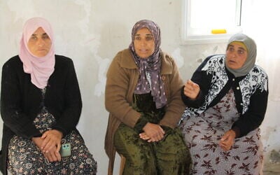 Tharwat Issam Muhammad (center), Maysoun Ahmad Issa Hammad (right) and another resident of the Palestinian West Bank hamlet of Jinba speak about an alleged settler and IDF assault on the dwelling, March 30, 2025. (Jeremy Sharon / The Times of Israel)