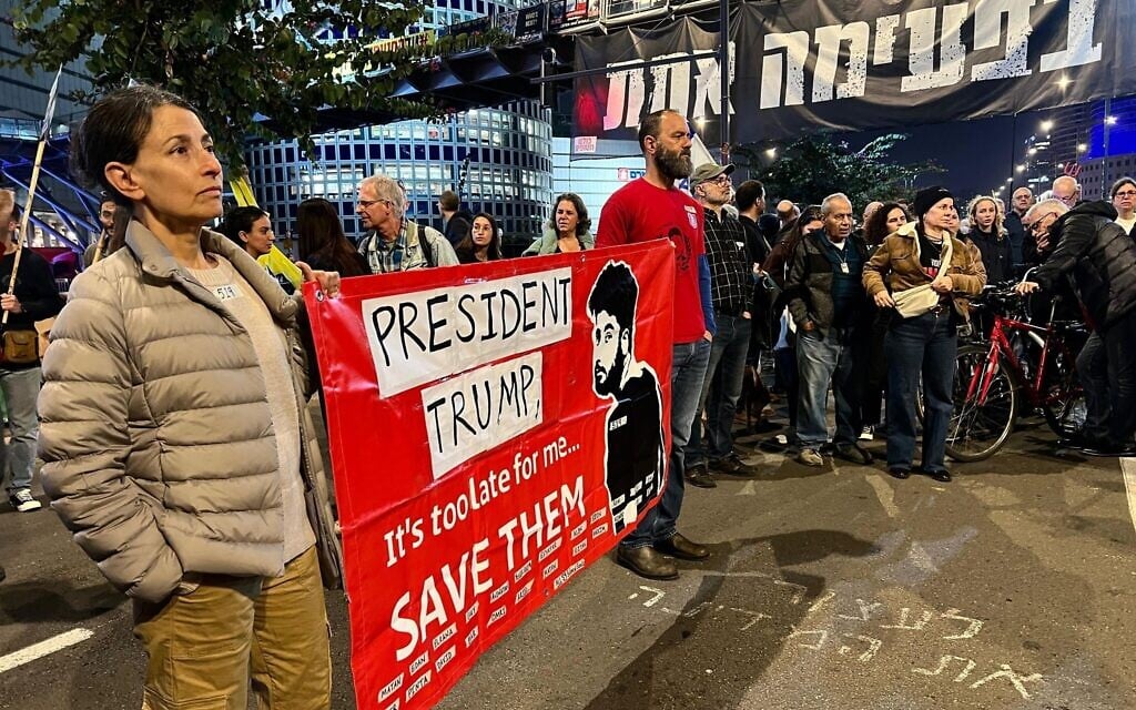 Rachel and Jon Goldberg-Polin hold a sign with a drawing of their son Hersh, who was murdered in Hamas captivity in Gaza, during a protest urging the release of all hostages, at the Begin Gate of the IDF's Kirya headquarters in Tel Aviv, March 8, 2025. (Yael Gadot / Pro-Democracy Protest Movement)