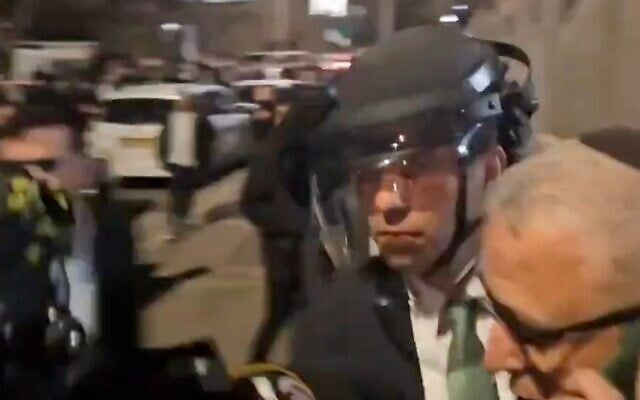 Beit Shemesh Mayor Shmuel Greenberg (in helmet) is rescued by police from a mob of ultra-Orthodox extremists, late March 19, 2025. (Screen capture X) Beit Shemesh Mayor Shmuel Greenberg (in helmet) is rescued by police from a mob of ultra-Orthodox extremists, late March 19, 2025. (Screen capture X)