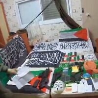 Islamic State memorabilia among other items found at the Taybeh home of an Arab Israeli accused of planning attacks inspired by the terror group, in a screenshot from video published on March 13, 2025. (Israel Police)