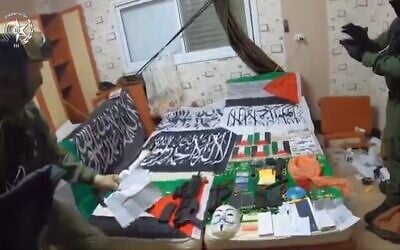 Islamic State memorabilia among other items found at the Taybeh home of an Arab Israeli accused of planning attacks inspired by the terror group, in a screenshot from video published on March 13, 2025. (Israel Police)