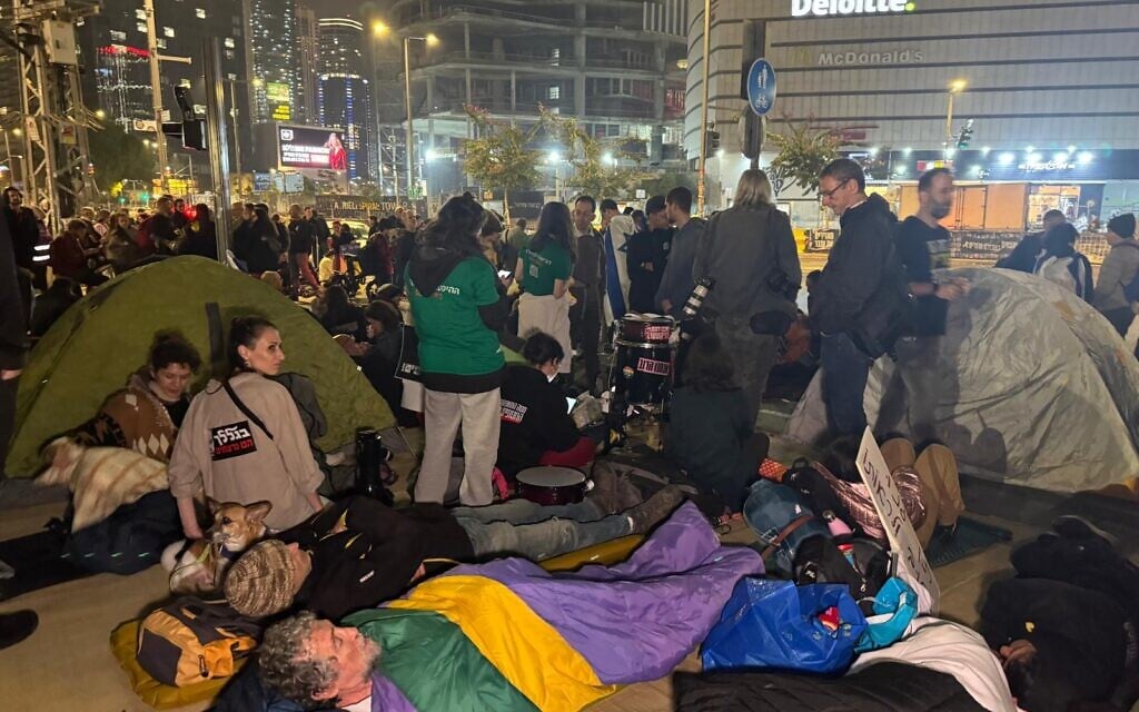 Protesters settle in for the night at the Begin Gate of the IDF's Kirya headquarters in Tel Aviv, March 8, 2025, vowing not to leave until all hostages are released from Gaza. (Naama Zeevi / Pro-Democracy Protest Movement)
