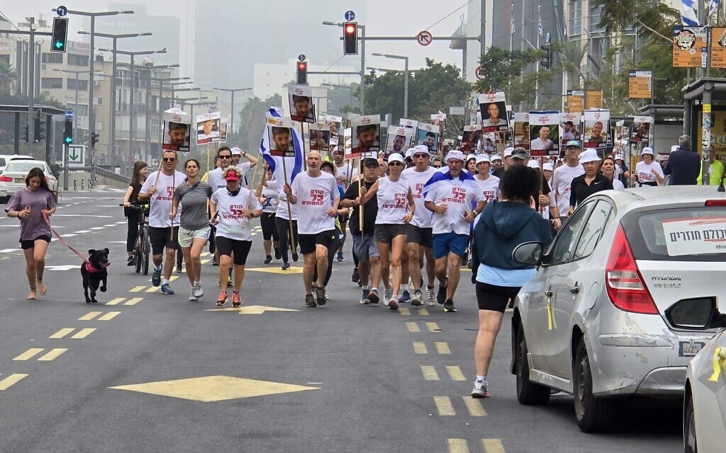 Activists take part in a run around the Defense Ministry headquarters in Tel Aviv, calling for the release of hostages held in Gaza, March 15, 2025. (Yair Sagie/Pro-Democracy Protest Movement)