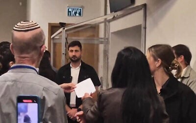 Einav Zangauker (center-right) passes a letter to Prime Minister Benjamin Netanyahu during a break in a hearing at his ongoing criminal trial, March 31, 2025 (Kan screenshot, via X)