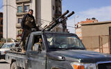 A member of the Syrian forces stands on a vehicle during deadly violence in which some 1,500 members of Bashar al-Assad's Alawite sect were killed, in Latakia, Syria, March 7, 2025. (Karam al-Masri/Reuters)