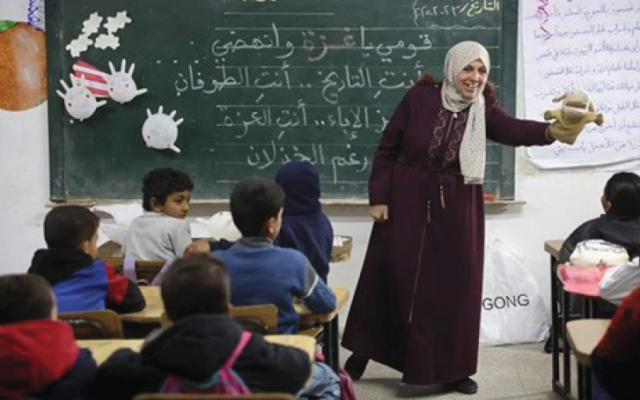 A teacher in Al-Nasr Elementary School in Gaza City stands next to a chalkboard with text that reads, "You are the Toufan" (the flood), a reference to the al-Aqsa Flood, Hamas's name for the October 7, 2023, massacre in Israel, February 23, 2025. (Omar AL-QATTAA / AFP) A teacher in Al-Nasr Elementary School in Gaza City stands next to a chalkboard with text that reads, "You are the Toufan" (the flood), a reference to the al-Aqsa Flood, Hamas's name for the October 7, 2023, massacre in Israel, February 23, 2025. (Omar AL-QATTAA / AFP)